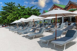 On the beach, white sand, sun loungers, beach umbrellas
