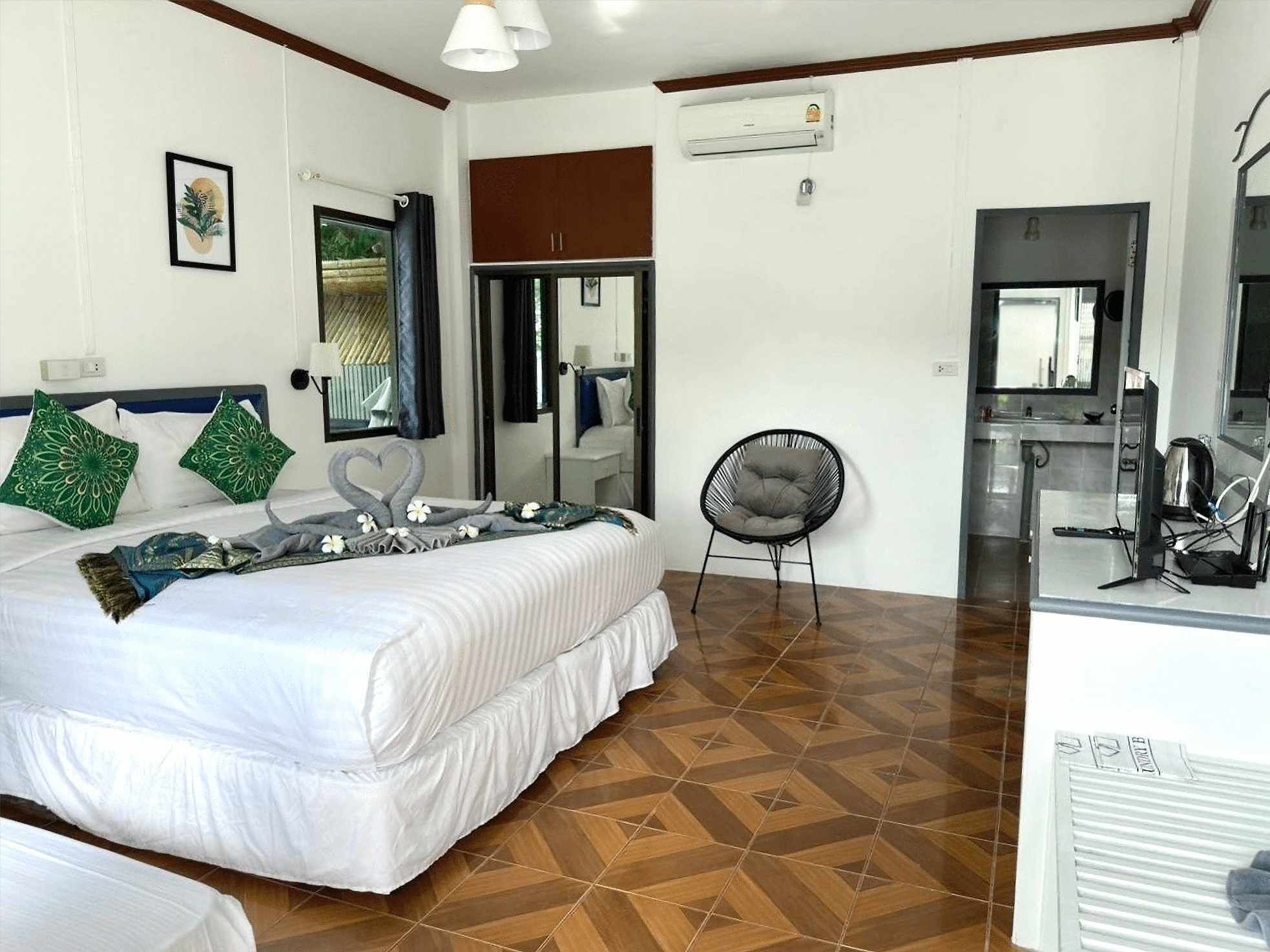 Una habitación de hotel con una cama, una silla, un escritorio y un equipo de aire acondicionado.