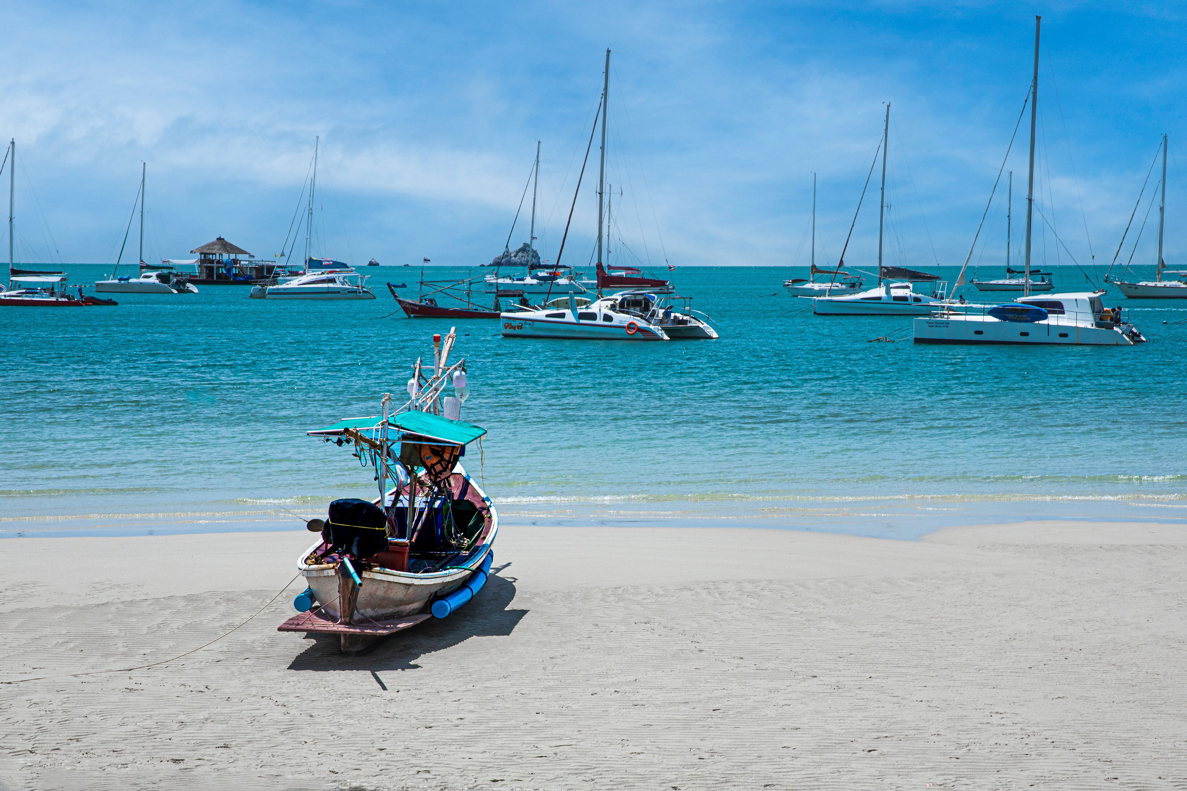 Une plage avec plusieurs bateaux et une petite cabane en arrière-plan.