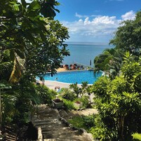 Una piscina al aire libre, sombrillas, tumbonas
