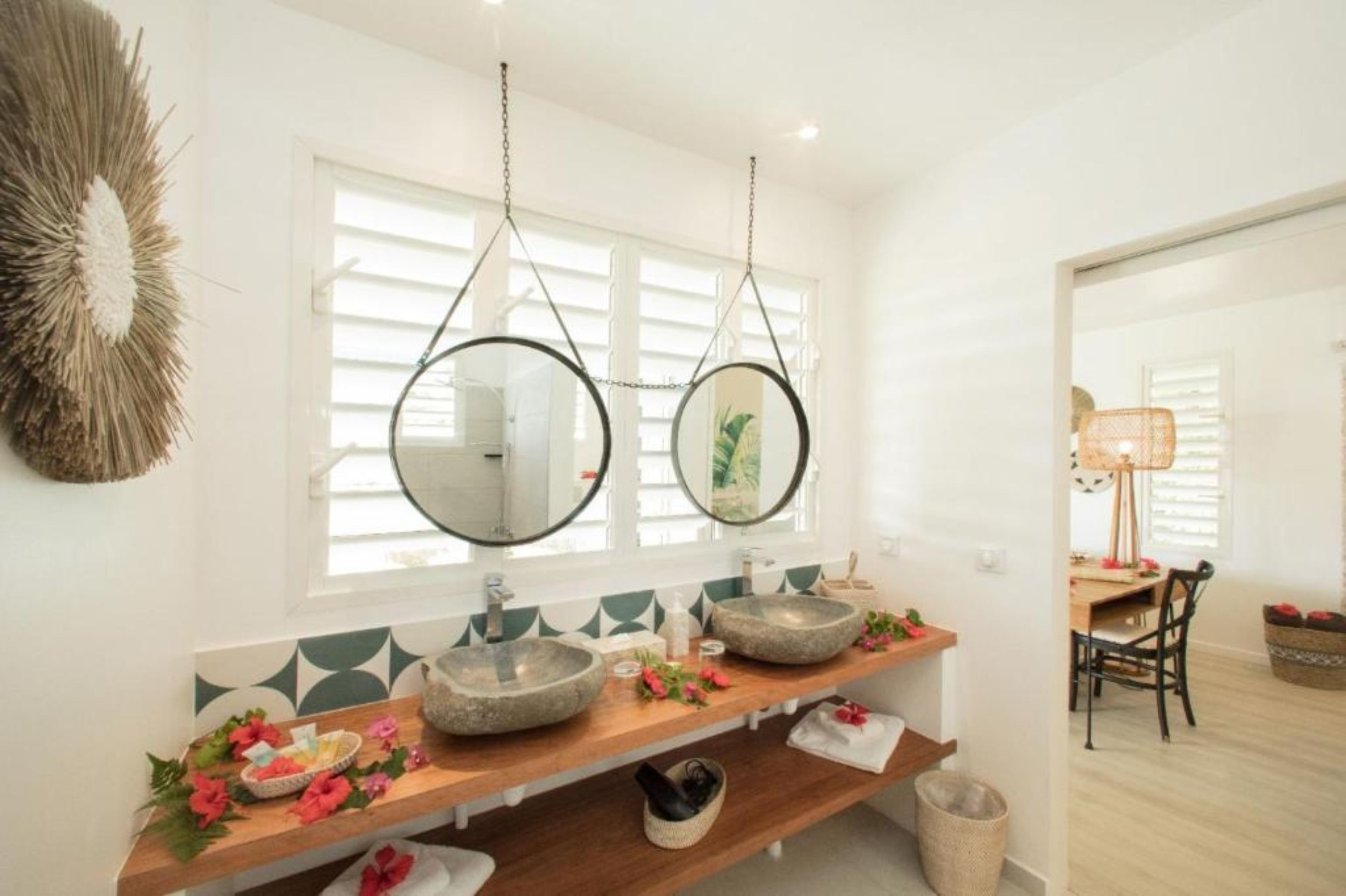 A bathroom with two stone sinks, a wooden vanity, and a large mirror.