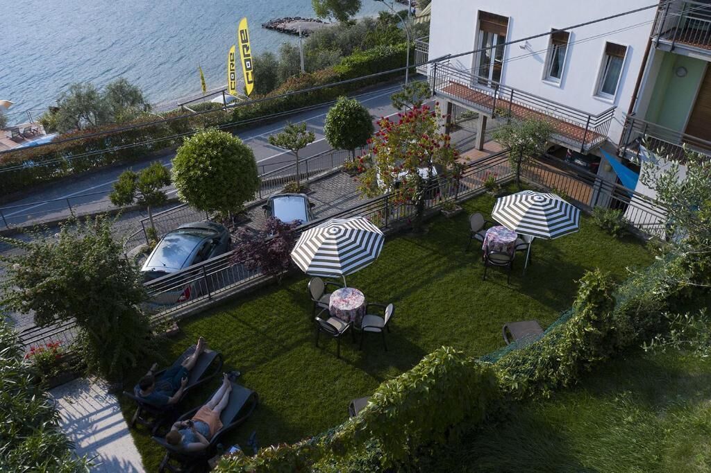 Une terrasse sur le toit avec une piscine, des chaises longues et des parasols.