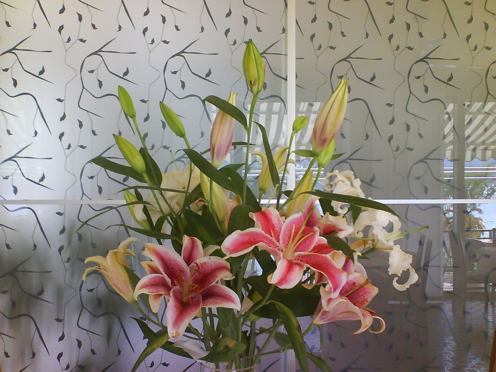 Eine Vase mit rosa und weißen Lilien.