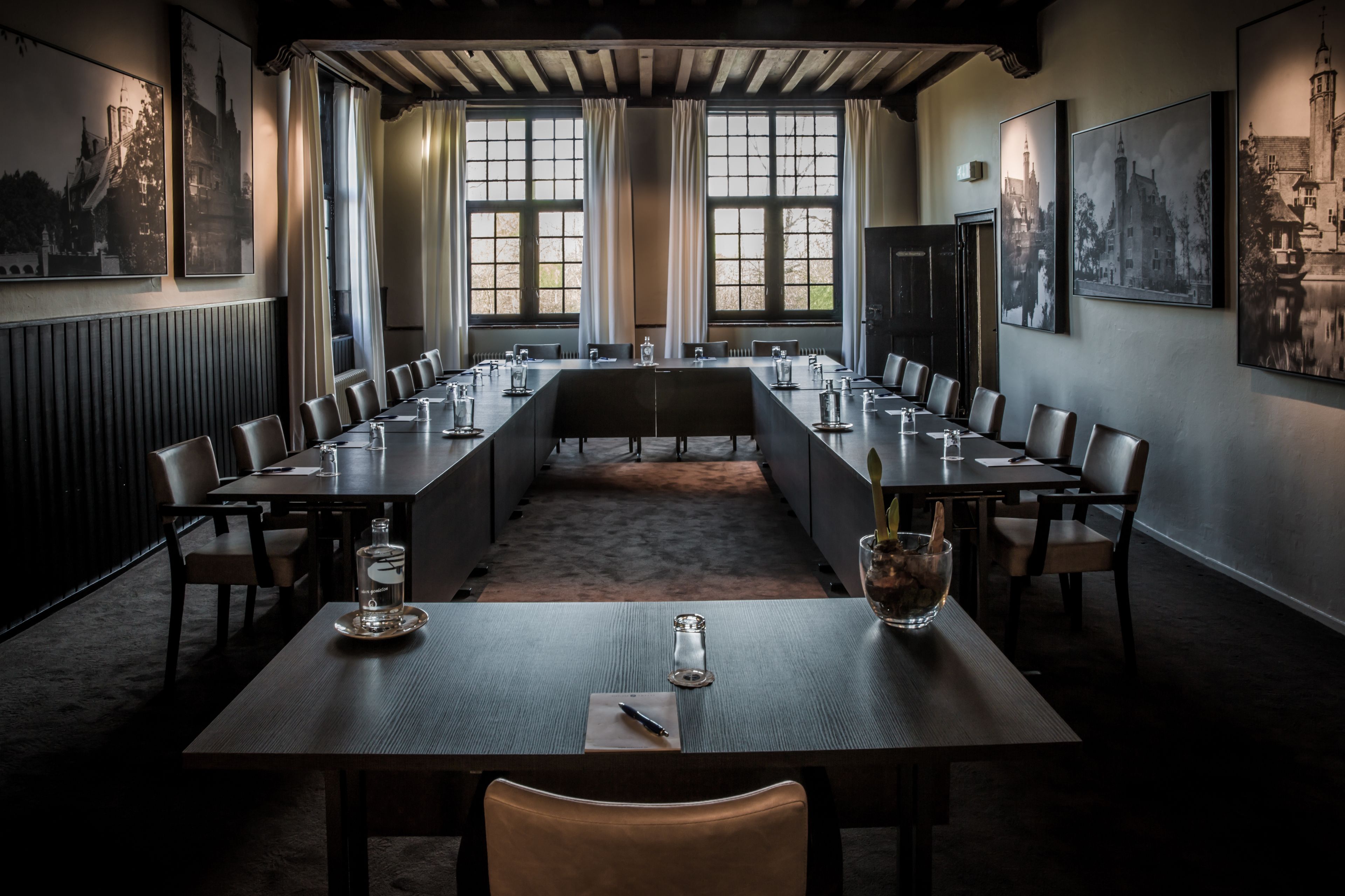 Un salón de conferencias con una larga mesa, sillas y vistas amplias a través de grandes ventanales.