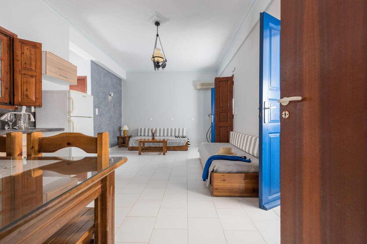 Una cocina moderna con armarios de madera, una mesa de comedor y una lámpara colgante.