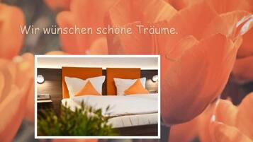 Een hotelkamer met een bed, kussens en een nachtkastje.