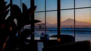 A view through a window with a metal grid, featuring a mountain and a bridge in the background. - 14 Floor Hotel (Yerevan)