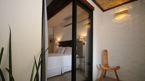 Une chambre à coucher avec un lit, une table de chevet et une chaise en bois.