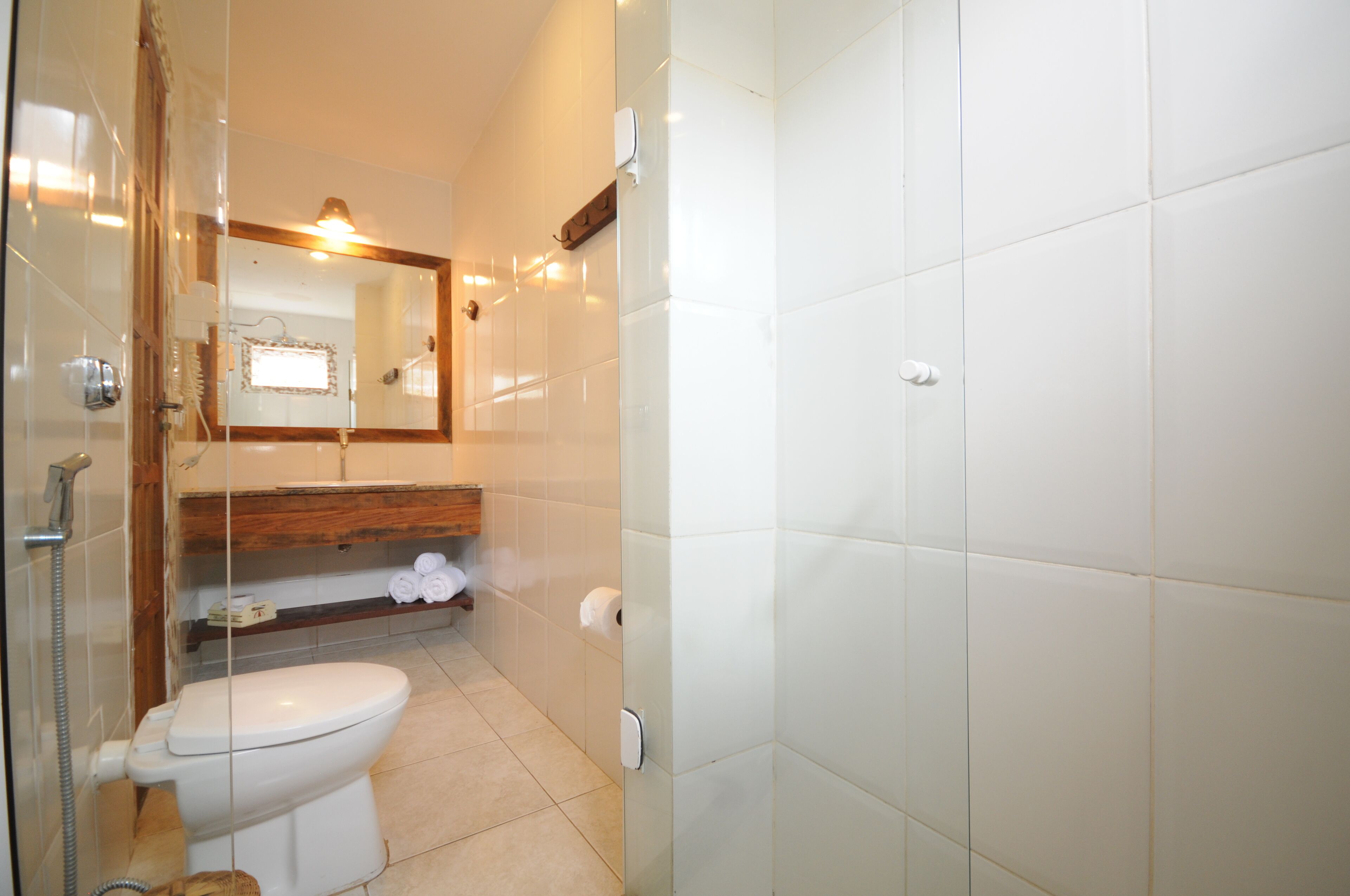 A bathroom with a toilet, a shower, and a mirror.
