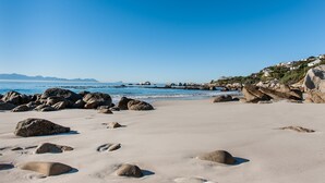 A beach with large rocks and a clear blue sky. - Whale View Manor Guesthouse (Cape Town)