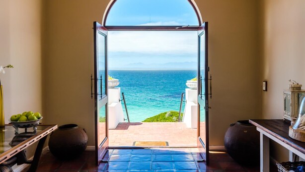 An open doorway leading to a balcony with a view of the ocean. - Whale View Manor Guesthouse (Cape Town)