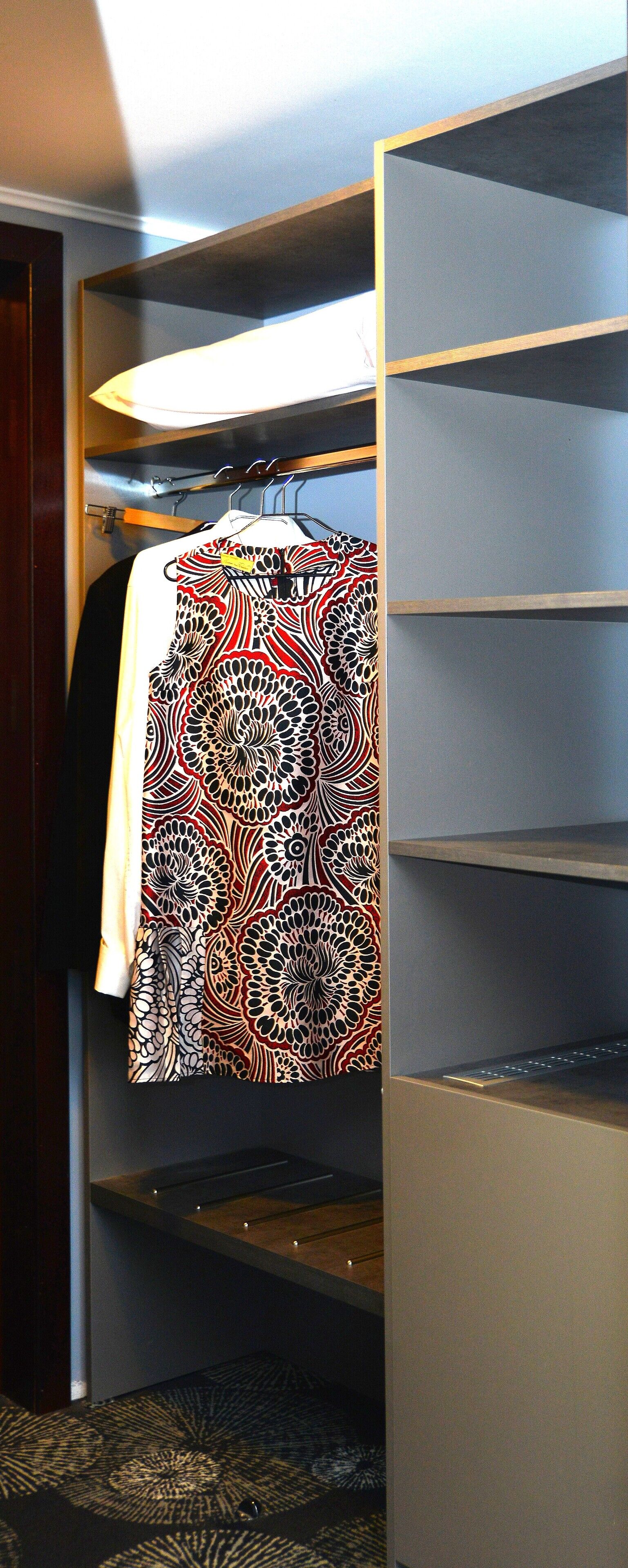 A walk-in closet with a hanging rack and shelves.