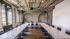 A conference room with a long table, chairs, and a clock on the wall. - CitiHotel Veliki (Novi Sad)