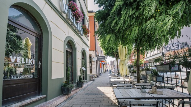 A café with outdoor seating, air conditioning, and a visible sign for 'VELIKI'. - CitiHotel Veliki (Novi Sad)