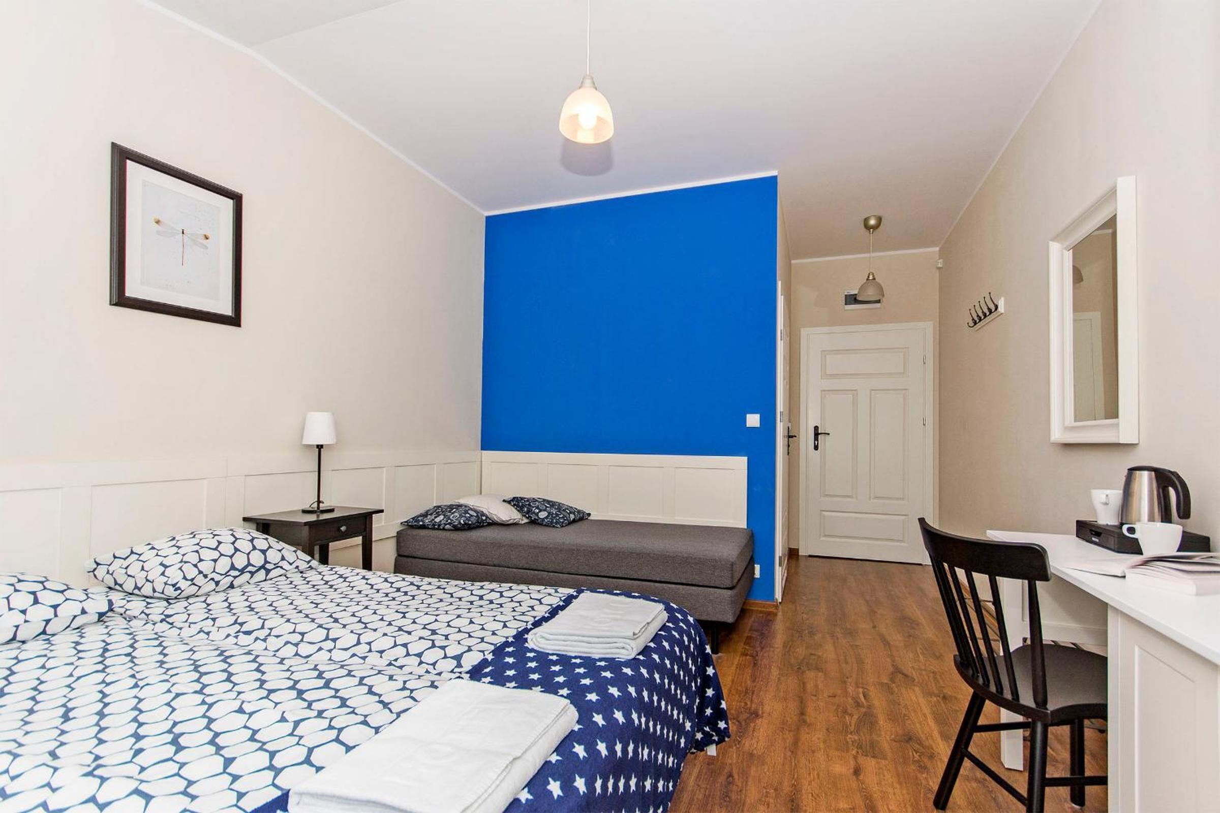 Une chambre à coucher comprenant un lit, une table de chevet, une lampe et un bureau avec une chaise.