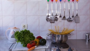 A kitchen with a pot of spaghetti, vegetables, and a kettle on the counter. - Sunflower Apartment (Dubrovnik)