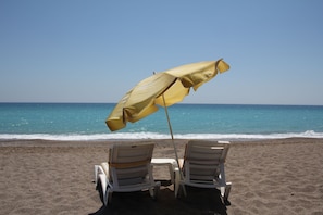 Two beach chairs with a yellow umbrella on a sandy beach. - Safak Beach Motel (Manavgat)