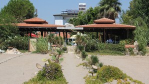 A cafe with a red-tiled roof and outdoor seating. - Safak Beach Motel (Manavgat)