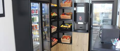 Um quiosque de autoatendimento com áreas refrigeradas e uma máquina de café.