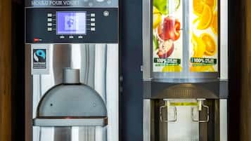 Twee koffieautomaten met digitale schermen en fruitafvuldispensers.