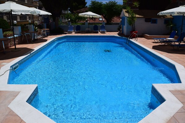 Una piscina al aire libre, sombrillas