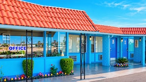 A building with a red tiled roof, blue exterior walls, and a clear sky. - Blue Mist Motel Florence (Florence)