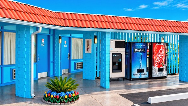 A building with a red roof and blue walls, featuring a Coca-Cola vending machine and an ice dispenser. - Blue Mist Motel Florence (Florence)