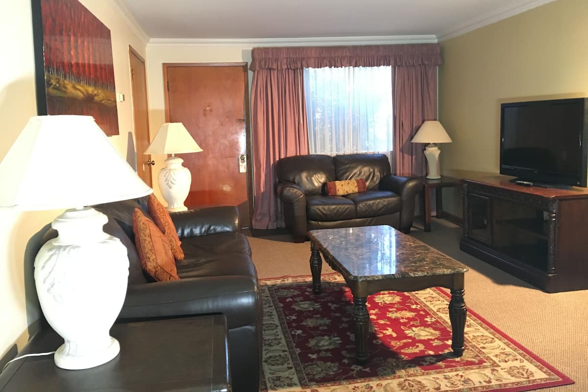 A living room with a sofa, a coffee table, a TV, and two lamps.