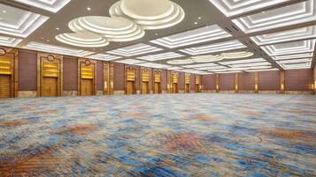 A spacious hall with a patterned carpet and recessed lighting on the ceiling.