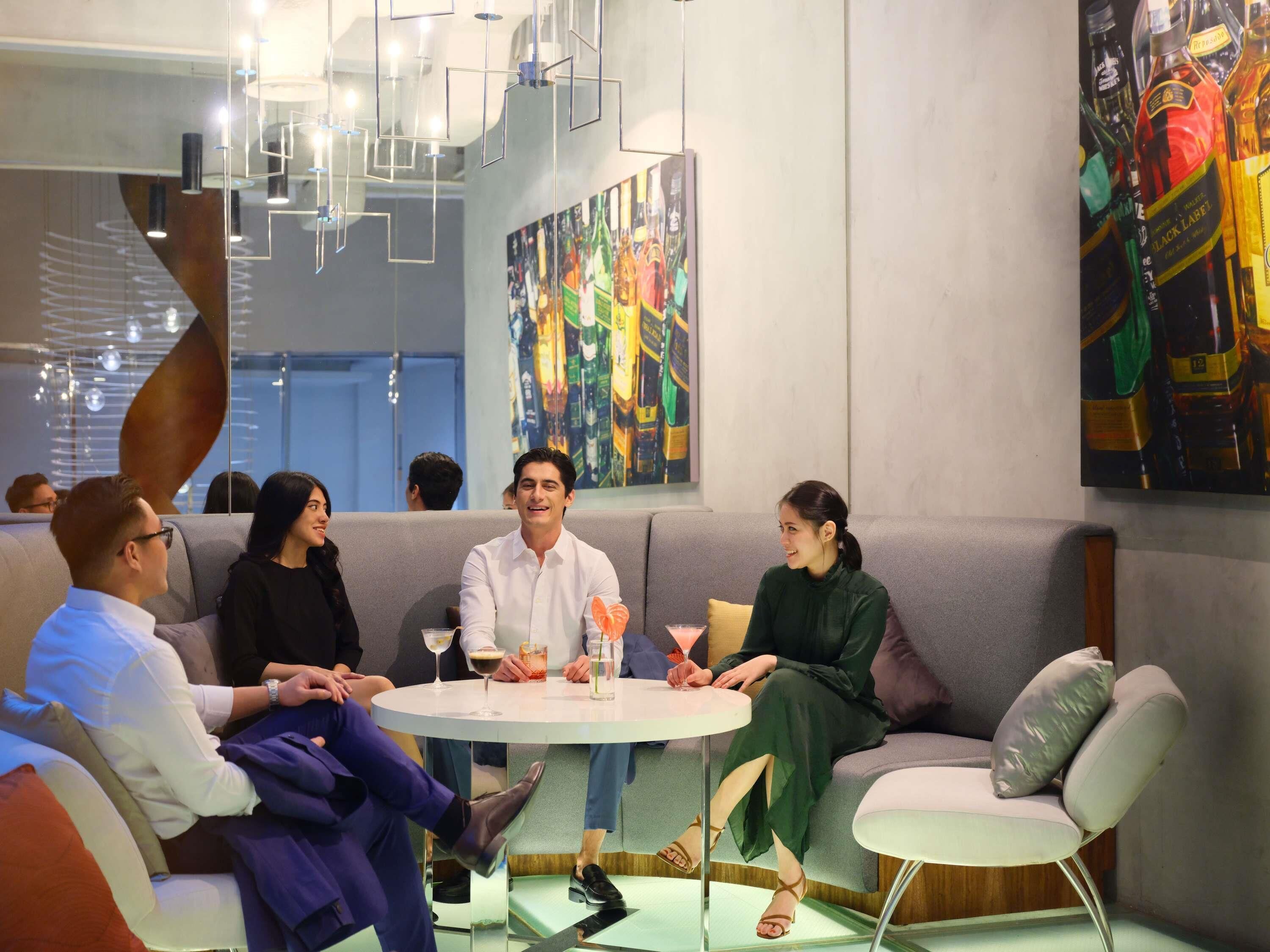A modern interior with a round table, seating, and abstract art on the walls.