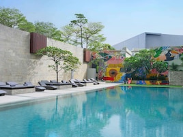Una piscina al aire libre, sillones reclinables de piscina