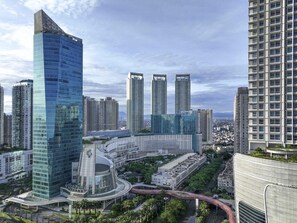 Un horizonte urbano moderno con rascacielos, incluyendo una estructura de vidrio distintiva con forma curva y un rascacielos alto con un diseño único.