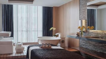 Relax in a spacious bathroom with a large bathtub, mirror, and window overlooking the surroundings.