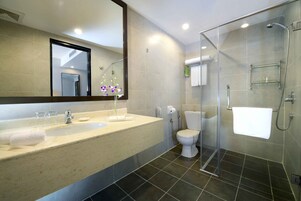 A modern bathroom with a large sink, toilet, and glass shower enclosure.