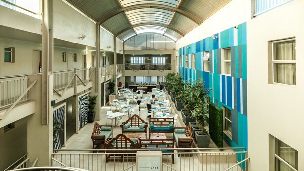 A multi-level indoor space with seating areas, a staircase, and a dining area.