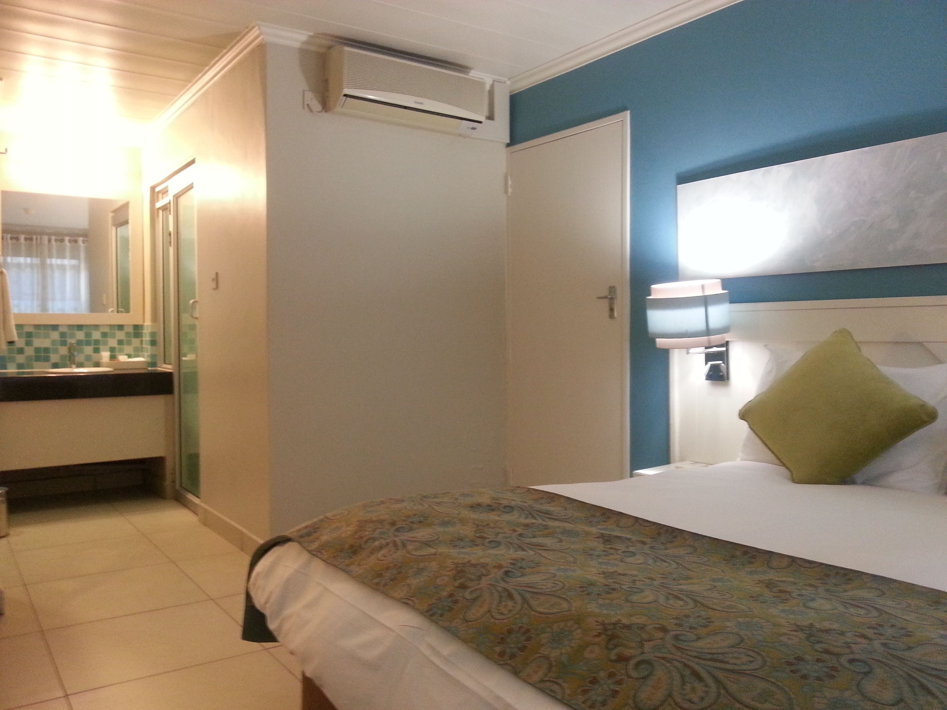 A hotel room with a bed, a bathroom, and a window.