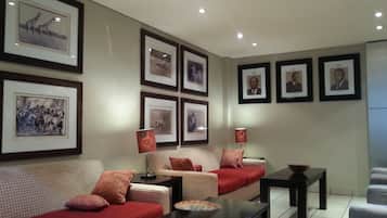 A modern living room with a sofa, a coffee table, and framed pictures on the wall.