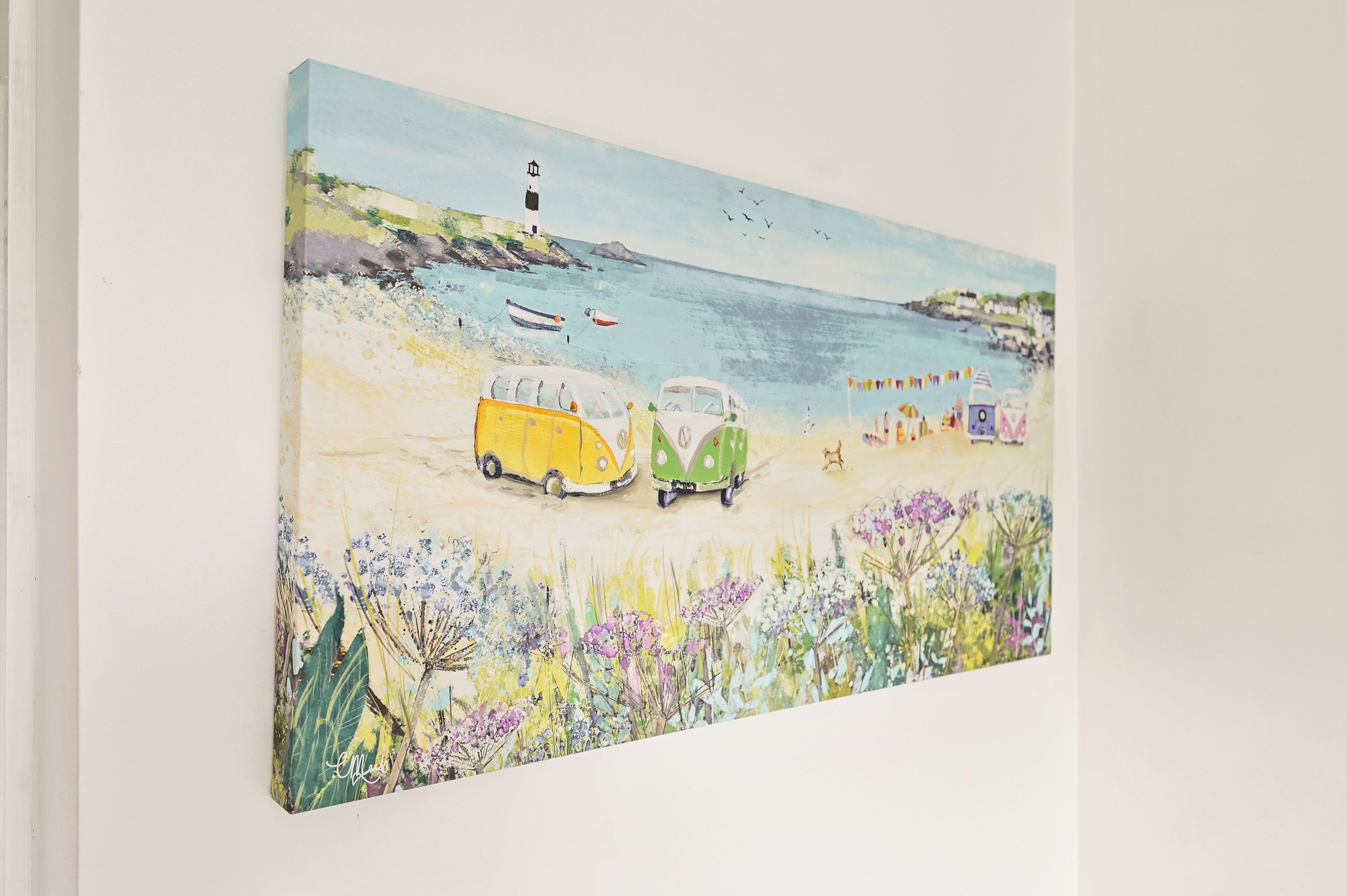 Eine Strandansicht mit einem Leuchtturm, Booten und bunten Fahrzeugen.