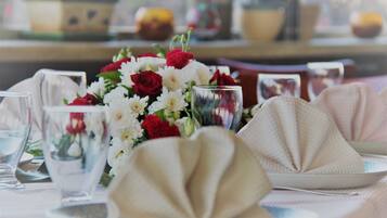 A table set for dining with a centerpiece of flowers, clear glassware, and folded napkins.