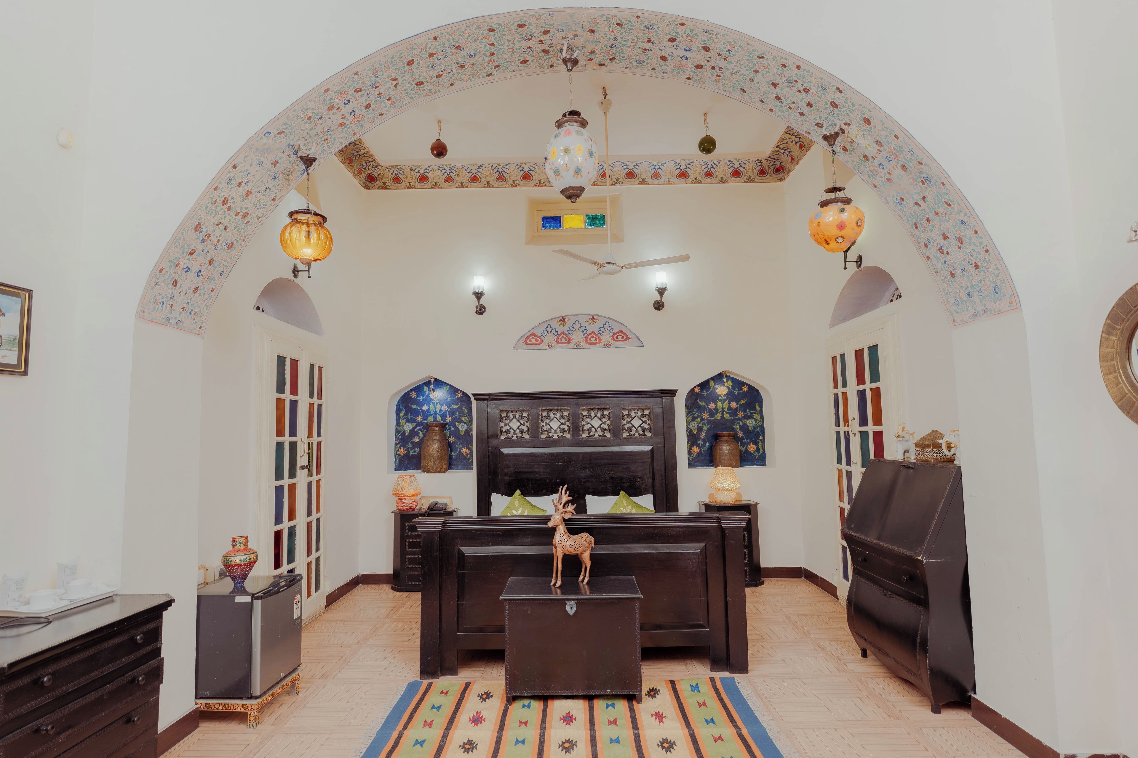 Une pièce au décor traditionnel, avec un canapé, une petite table, une statue de cerf décorative et un tapis à motifs.