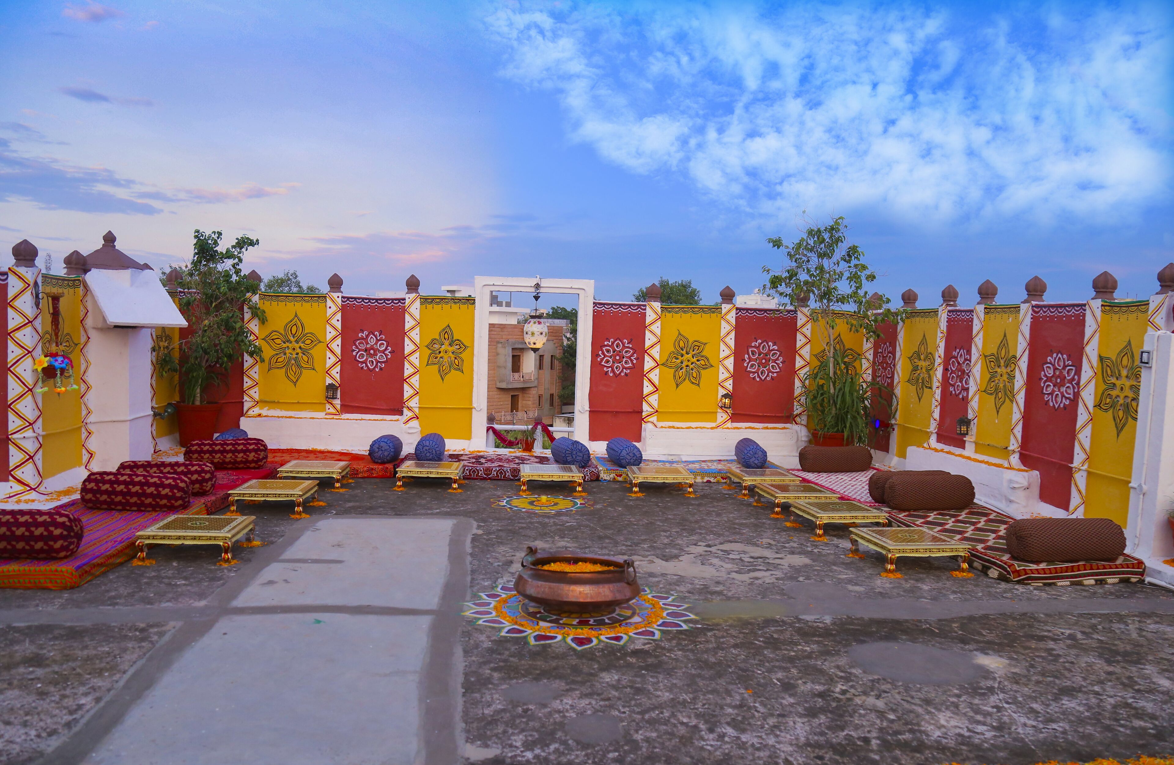 A courtyard with a central decorative area, seating arrangements, and a gate.