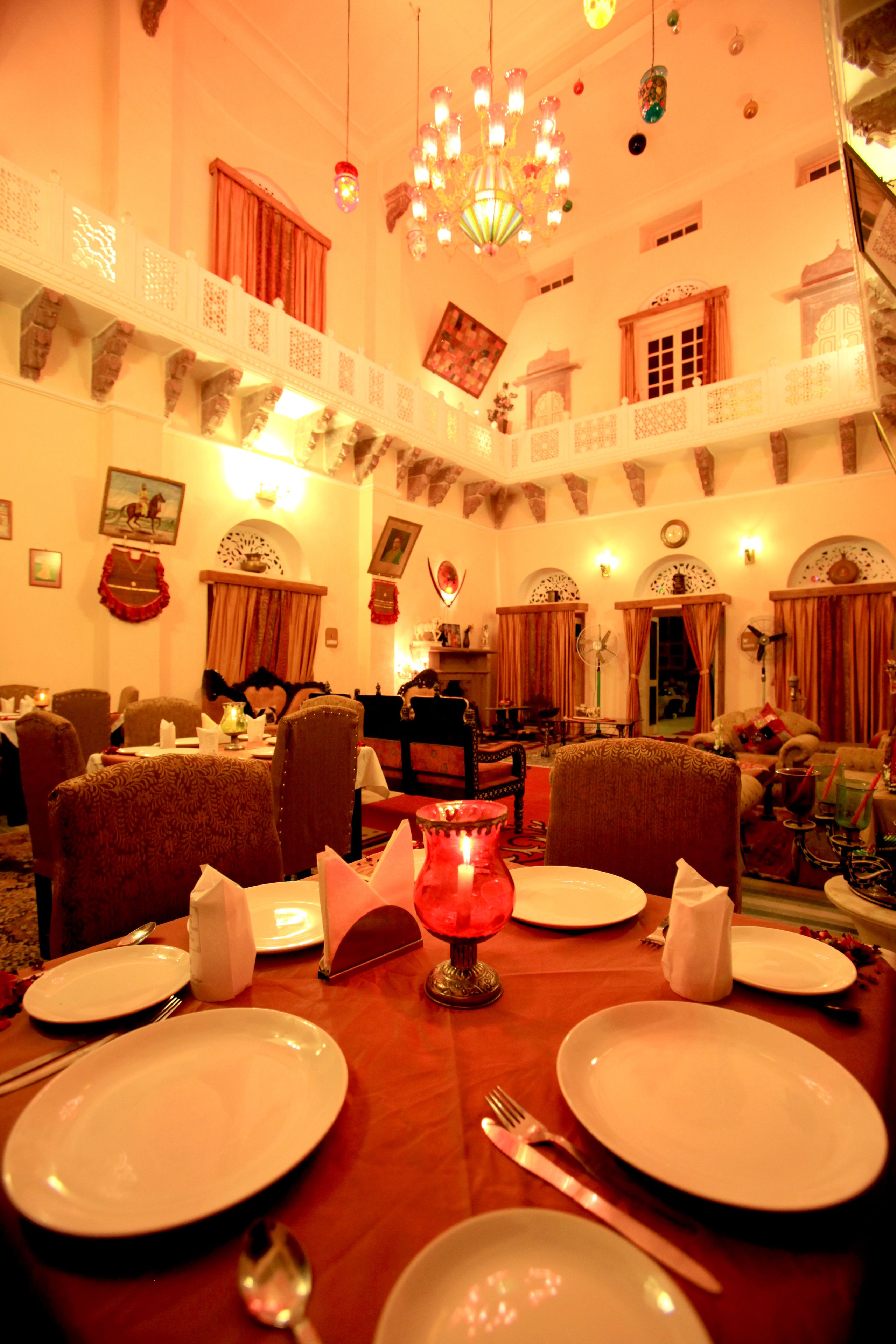 A dining area with a wooden table set for a meal, surrounded by chairs.