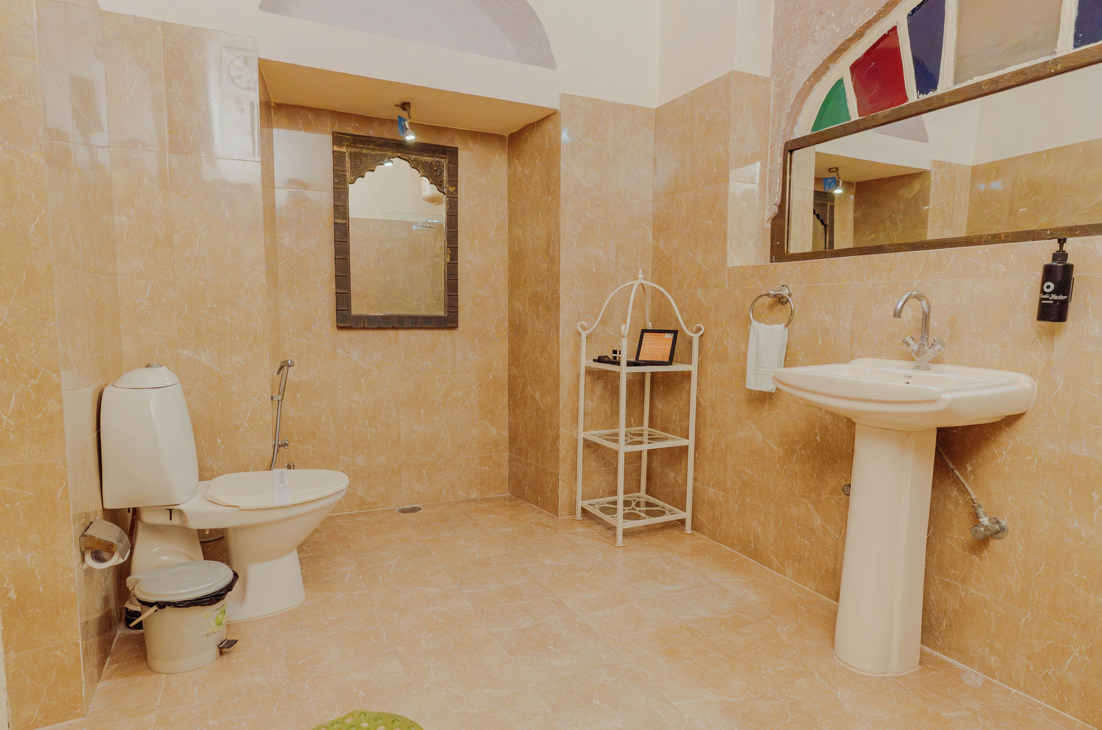 A bathroom with a toilet, sink, and a mirror.