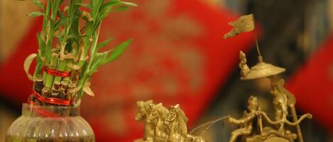 A decorative vase with green plants and a golden horse-drawn carriage.