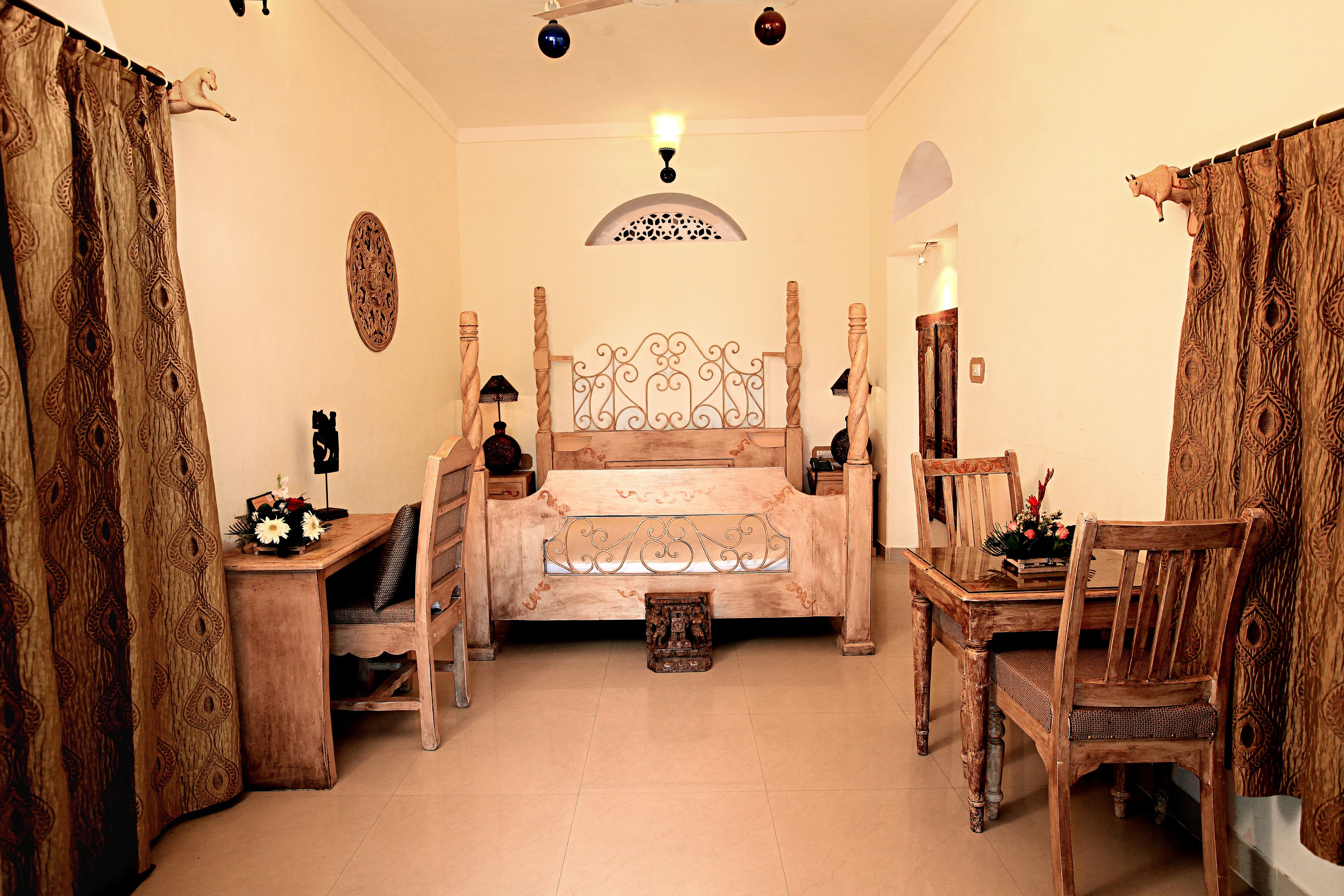 Un dormitorio tradicional con cama de madera, un escritorio y una silla.