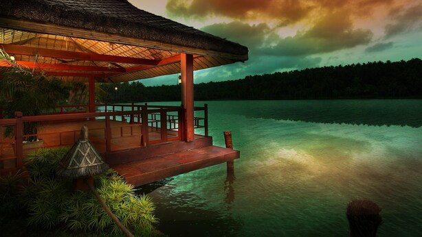 A wooden deck with a thatched roof overlooking calm water, surrounded by lush greenery. - Fragrant Nature Backwater Resort & Ayurveda Spa (Kollam)