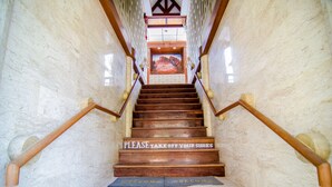 A staircase with a sign that says "PLEASE TAKE OFF YOUR SHOES" leading to a room with a mural. - Sea Garden Resort - Haad Rin (Ko Pha-ngan)