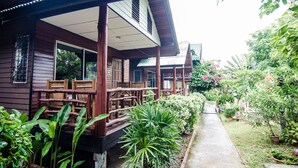 A wooden building with a covered porch and outdoor seating. - Sea Garden Resort - Haad Rin (Ko Pha-ngan)