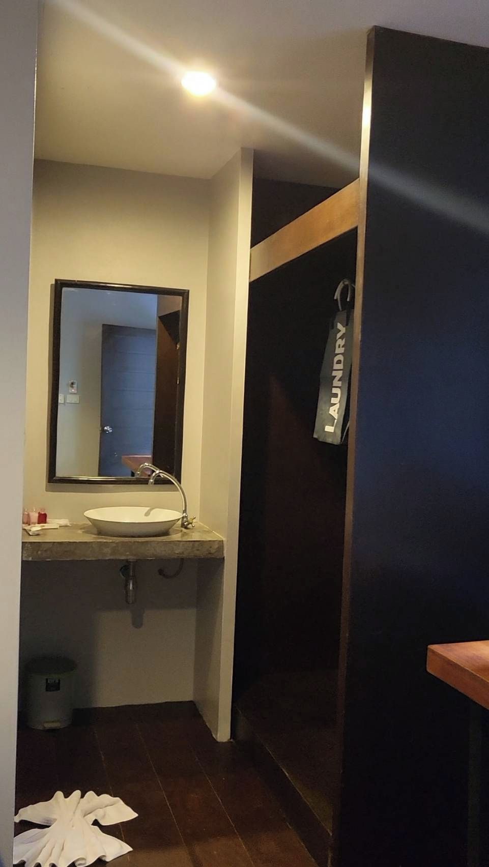 A bathroom with a sink, mirror, and a towel hanging on a rack.