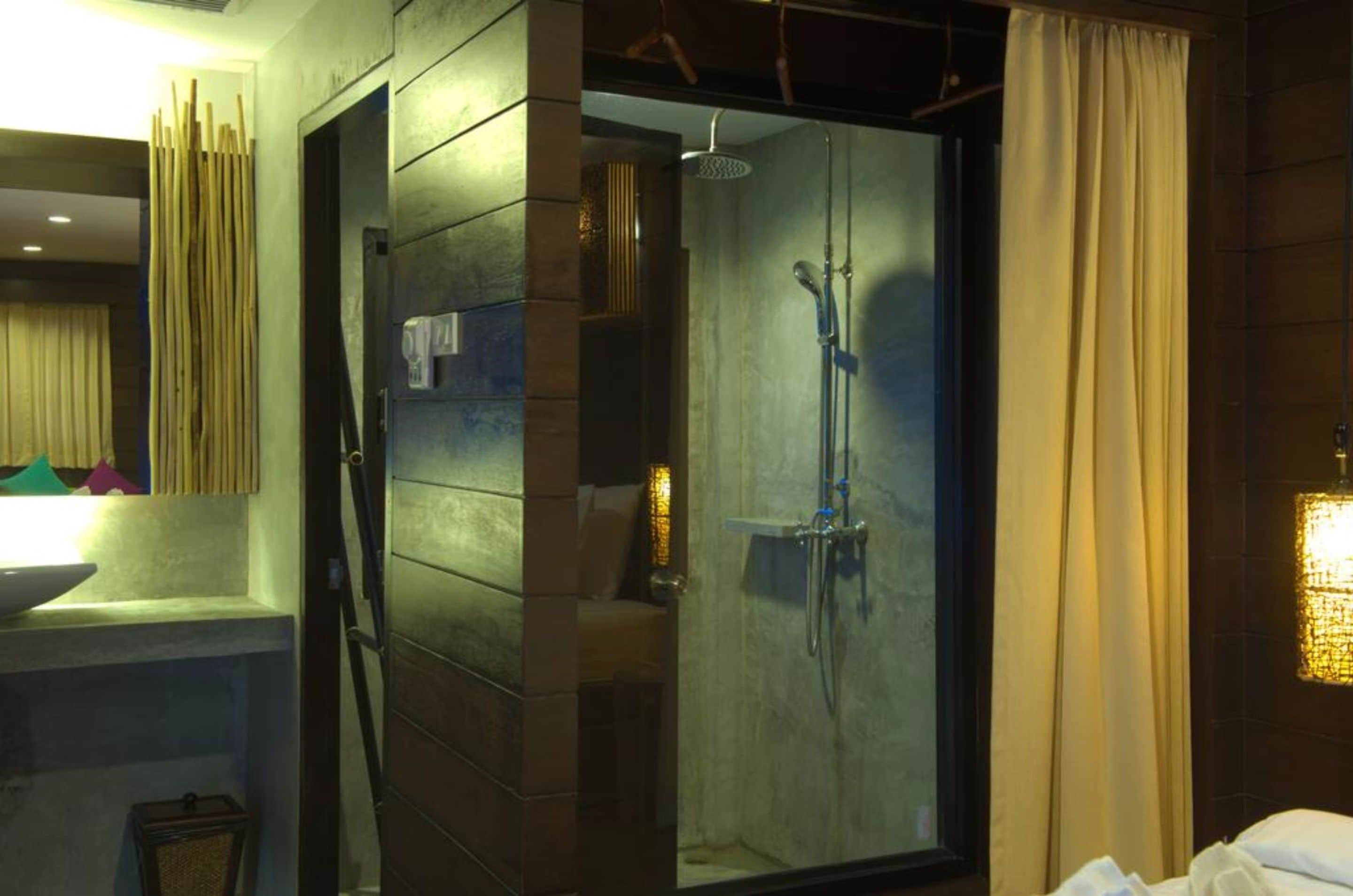 A modern bathroom with a glass shower enclosure, a sink, and a mirror.